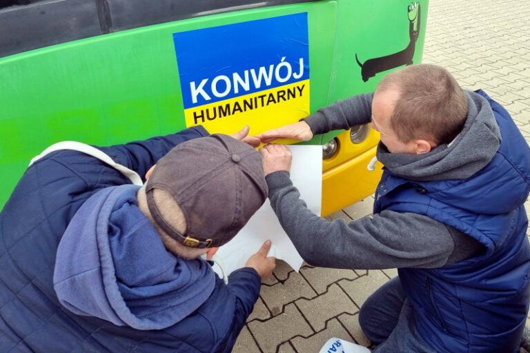 naklejanie na autobusie oznaczen konwoj humanitarny