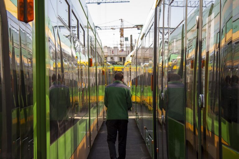 Motorniczy idący pomiędzy tramwajami