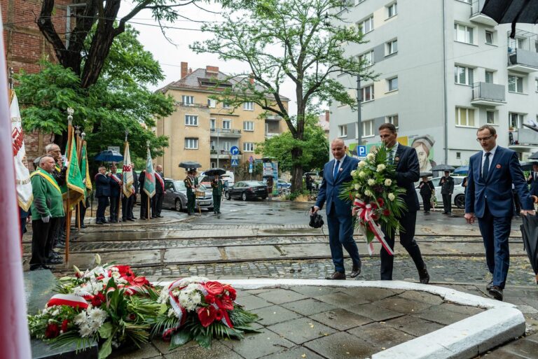 Zarząd MPK Poznań z kwiatami pod pomnikiem przy bramie dawnej zajezdni Gajowa