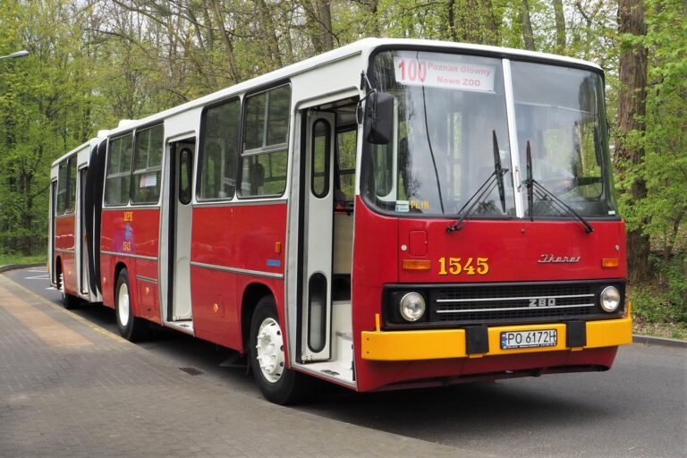 Czerwony autobus, Ikarus 280, na jezdni. W tle drzewa