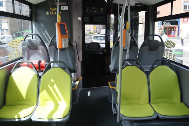 Wnętrze autobusu, widoczne siedzenia w limonkowym kolorze