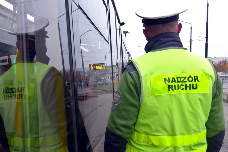 Pracownik MPK Poznań w odblaskowej kamizelce z napisem Nadzór Ruchu przy tramwaju
