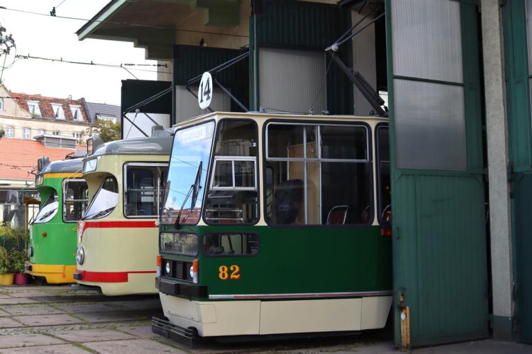 Stare tramwaje w bramie hali. Na pierwszym planie zielony wagon z numerem 82