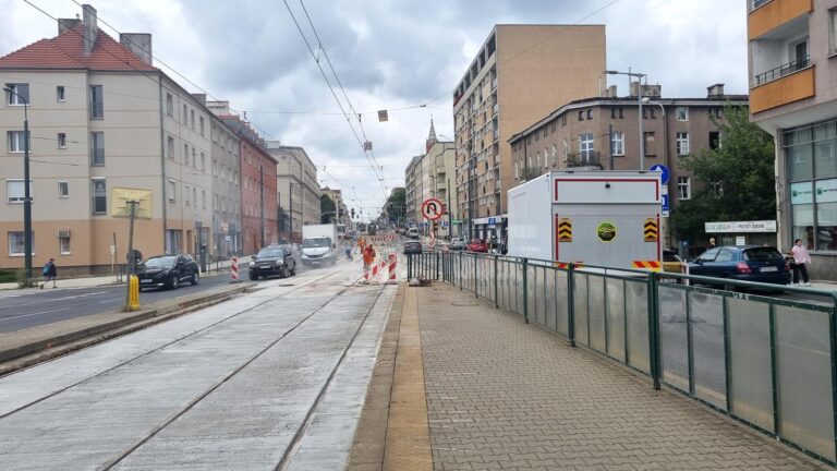 Prace na torowisku. Widoczne szyny i nowa betonowa nawierzchnia