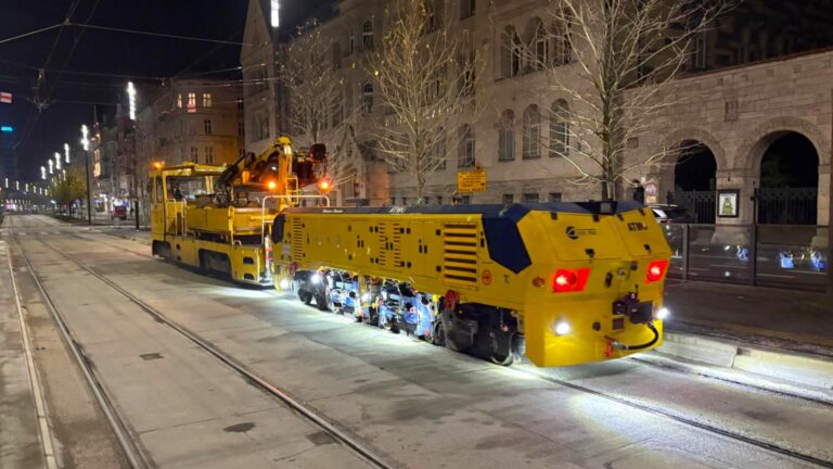 Żółta maszyna na torowisku w centrum miasta - zdjęcie wykonane w porze nocnej