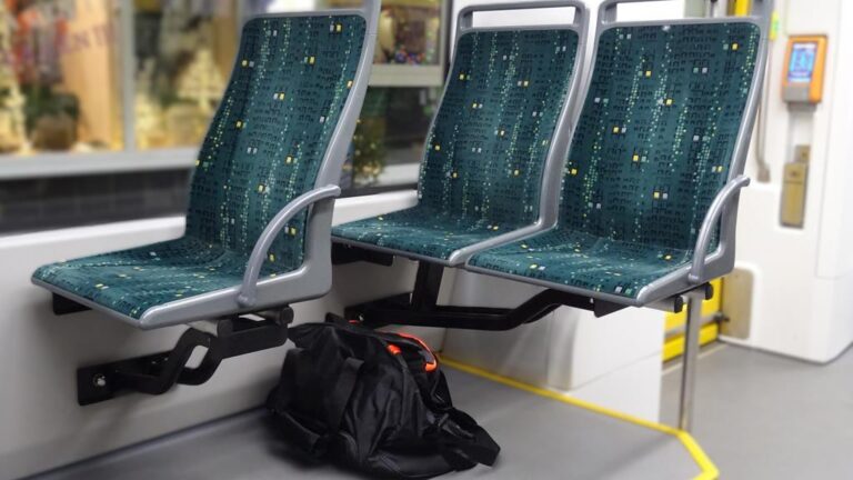 Czarna torba leżąca pod siedzeniami tramwaju