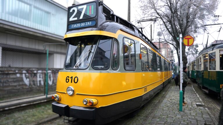 Żółty tramwaj na przystanku w dawnej zajezdni