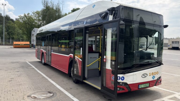 Biało-czerwony autobus stojący na placu