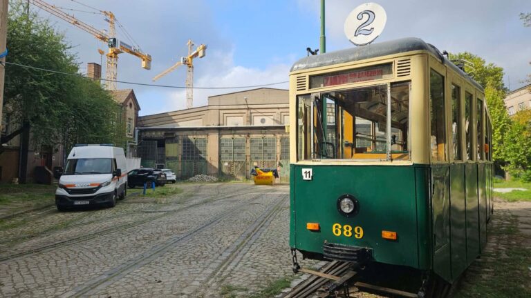 Historyczny wagon 4N, a w tle budynek hali dawnej zajezdni Gajowa