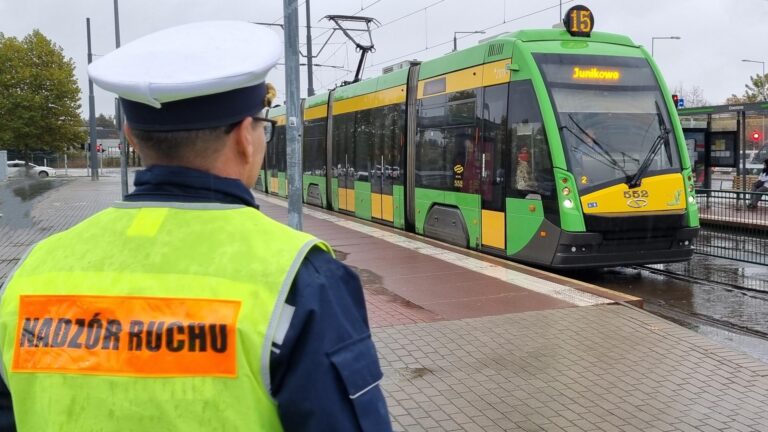 Umundurowany mężczyzna w kamizelce z napisem nadzór ruchu przy tramwaju